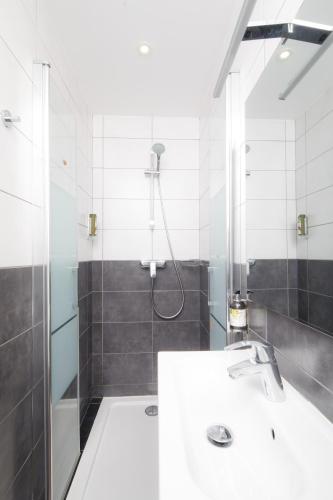 a bathroom with a shower and a white sink at Saint Aubin Logis Hôtel & Restaurant in Saint-Aubin-sur-Mer
