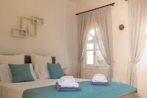 a bedroom with two towels on a bed with a window at Oia Sunset Luxury Villa in Oia