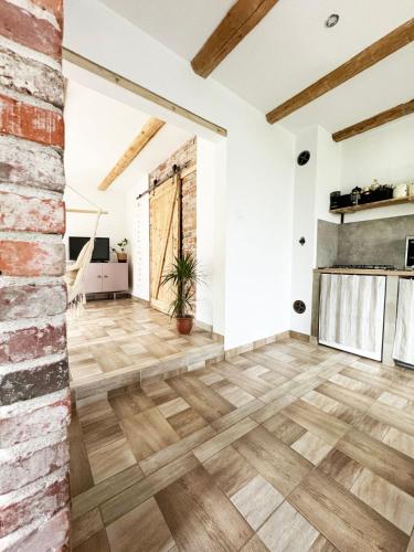 an empty room with wooden floors and a brick wall at Na początku in Budzów