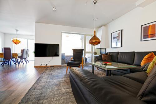 a living room with a couch and a table at Gjermesøy Luxury Apartment in Ballstad