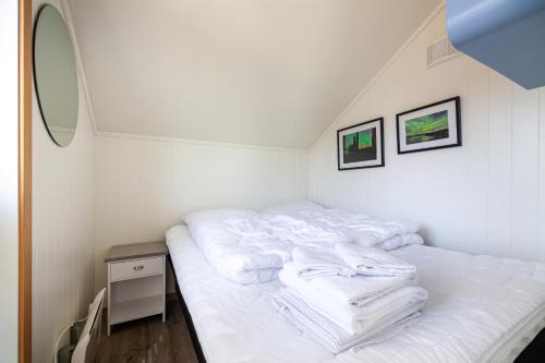 a bed with white towels on it in a room at Gjermesøy Luxury Apartment in Ballstad