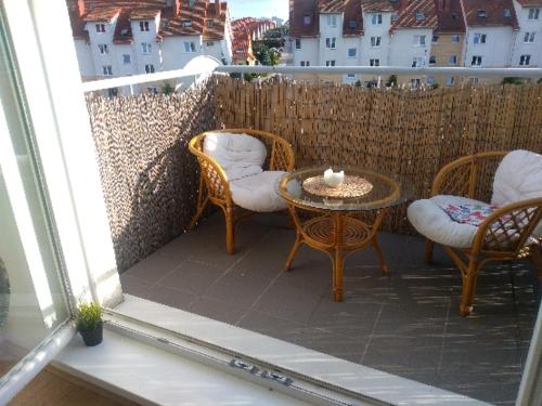 um pátio com cadeiras, uma mesa e uma cerca em Jasne słoneczne mieszkanie niedaleko lotniska em Gdansk