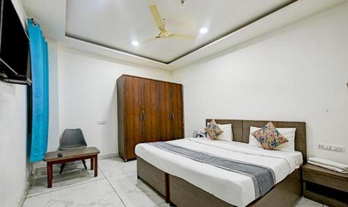 a bedroom with a large bed and a television at FabExpress The Maharaja Grand in New Delhi