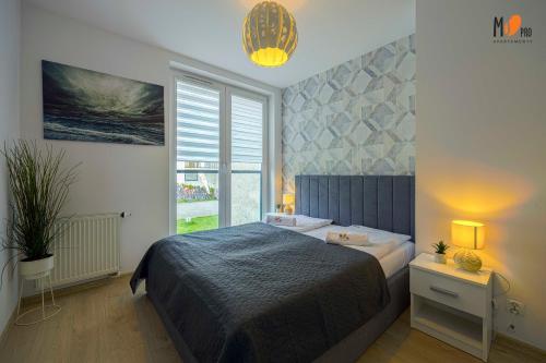 コウォブジェクにあるMS Pro Apartamenty De Lux Classのベッドルーム1室(ベッド1台、大きな窓付)