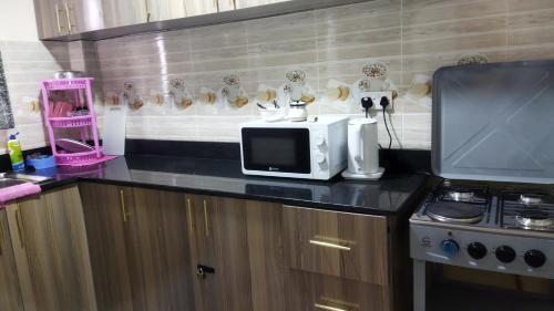 y cocina con microondas y fogones. en Lacasa accommodation en Naivasha
