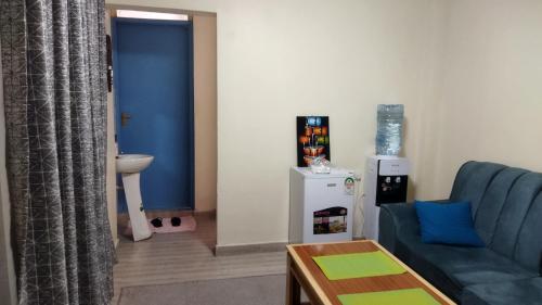 - un salon avec un canapé bleu et une table dans l'établissement Lacasa accommodation, à Naivasha