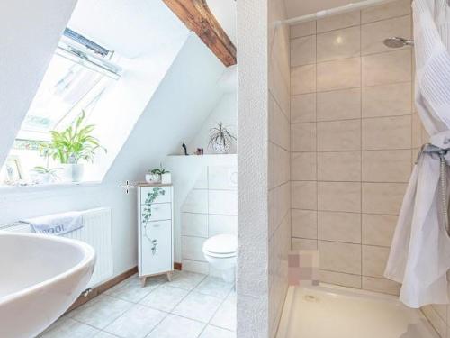 a bathroom with a white tub and a toilet at Ferienwohnung kleiner und großer Stern in Stoltebüll