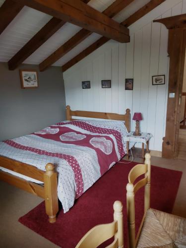 een slaapkamer met een bed met een rode en witte deken bij Chambre privee in Sallanches