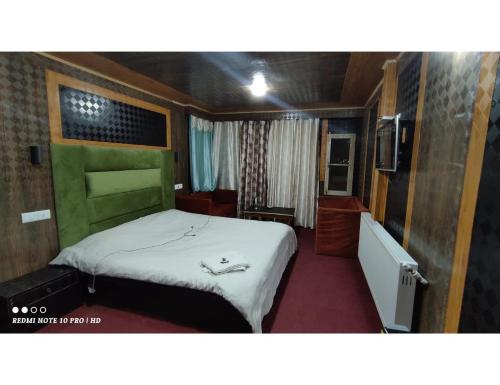 een kleine slaapkamer met een bed in een kamer bij Hotel Gulmarg Sahara, Jammu and Kashmir in Gulmarg