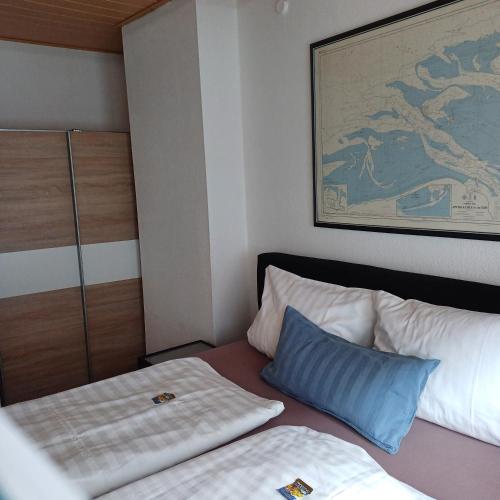 a bedroom with a bed with a pillow and a painting at Alt-Emder Bürgerhaus in Emden