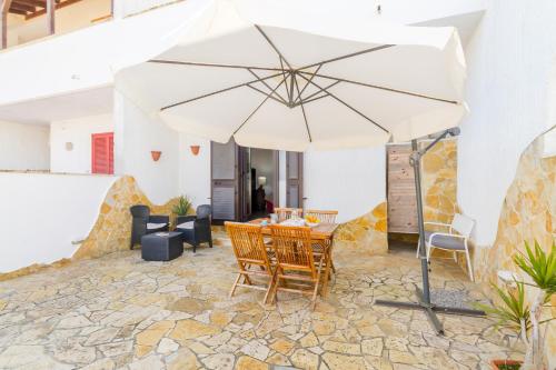una mesa y sillas bajo una sombrilla en un patio en Villetta Bel Mare With Garden Near Sea - Happy Rentals, en Melendugno
