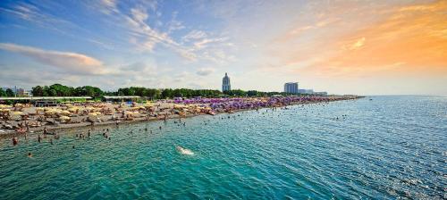 a beach with umbrellas and people in the water at Monte Carlo in Batumi