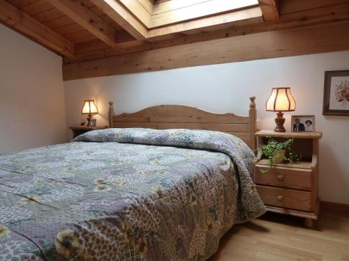 1 dormitorio con 1 cama y 2 mesitas de noche en Residence Casa Canazei, en Canazei