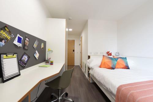 a bedroom with two beds and a desk with a chair at For Students Only Cosy Ensuite Rooms With Private Bathrooms at Dobbie's Point in Glasgow in Glasgow