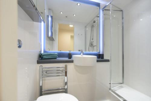 y baño con aseo, lavabo y espejo. en For Students Only Cosy Ensuite Rooms With Private Bathrooms at Dobbie's Point in Glasgow en Glasgow