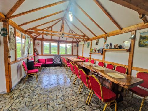 a dining room with tables and red chairs at Stelele Coziei in Valcea