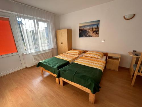 1 dormitorio con 1 cama con sábanas de color verde y naranja en Pokoje gościnne ZUZA en Władysławowo
