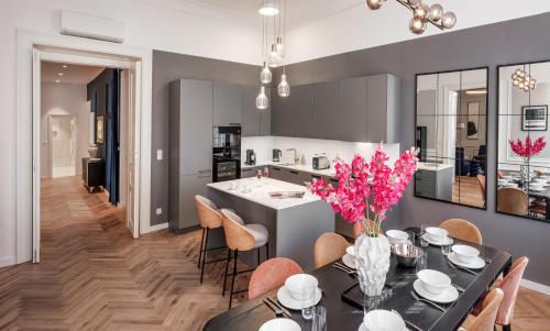 a kitchen and dining room with a table with pink flowers at River Dance Suites by Adrez in Prague