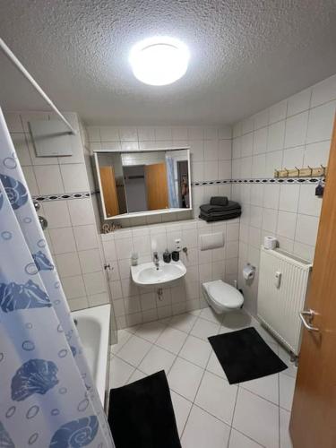 a bathroom with a sink and a toilet and a mirror at Fewo 3 in Gotha