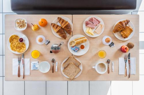 una mesa de madera con productos para el desayuno en Ace Hotel Roanne, en Mably