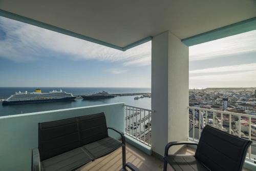 a balcony with a bench and a cruise ship at Ocean Vista - Premium CityCenter in Ponta Delgada