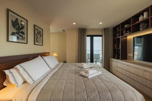 a bedroom with a large bed with white pillows at Ocean Vista - Premium CityCenter in Ponta Delgada