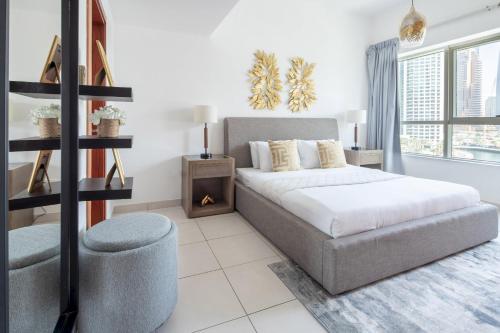 ein weißes Schlafzimmer mit einem Bett und einem Stuhl in der Unterkunft Frank Porter - Marina Views Tower in Dubai