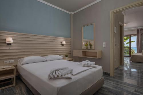 a bedroom with a large white bed and a window at Alkioni By The Sea in Siviri