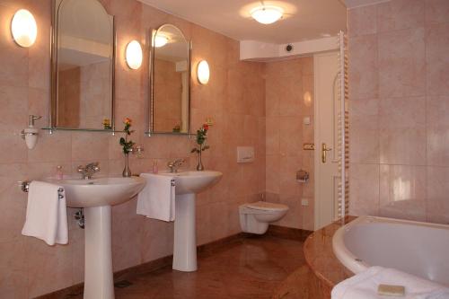 a bathroom with two sinks and a tub and a toilet at PRIVILLAGE Stare - B&B in Bohinj