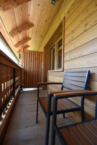 a wooden porch with a bench on the front of a cabin at PRIVILLAGE Stare - B&B in Bohinj