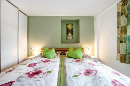 a bedroom with two beds with green pillows at Ferienwohnung Birke in Altusried