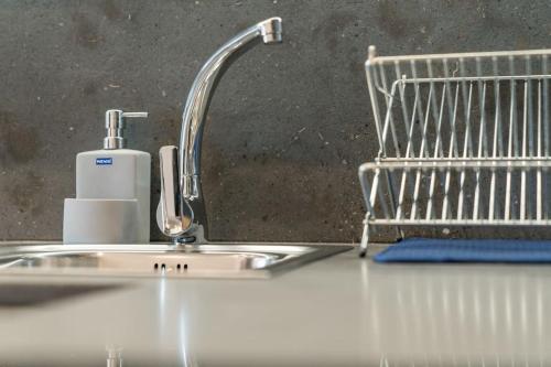 a kitchen sink with a faucet and a shopping cart at SeaHomes Vacations - CALA BANYS Apt in Lloret de Mar