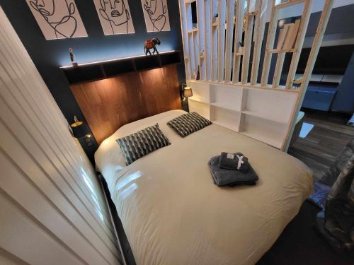 a bedroom with a bed with a hat on it at L'Ecrin sous les Chênes in Gradignan