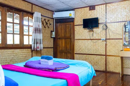 mały pokój z łóżkiem i telewizorem w obiekcie Ruenpakkiangnan เรือนพักเคียงน่าน w mieście Phitsanulok