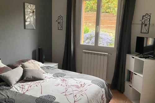 een slaapkamer met een bed, een televisie en een raam bij Villa de plein pied 3 chambres avec piscine. in Martigues
