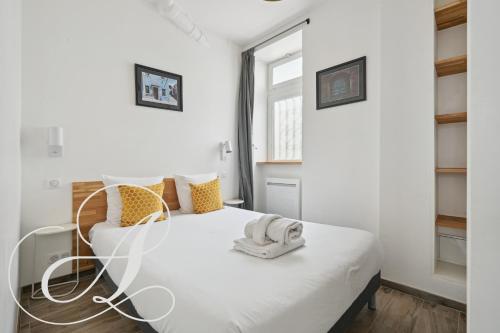 - une chambre avec un lit blanc et un téléphone dans l'établissement Roxane, 2 chambres dont une en souplex Paris 14e, à Paris
