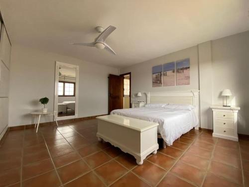 a bedroom with a white bed and a ceiling fan at El Olivar Lidia in Puerto del Rosario