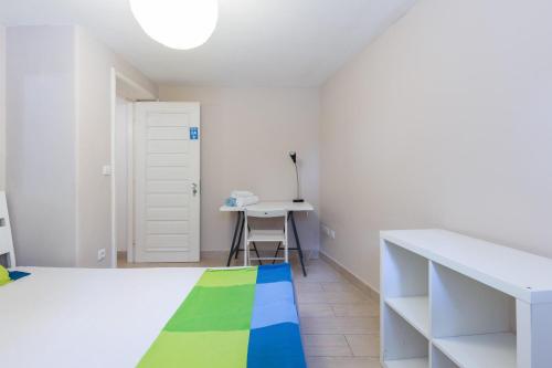 Habitación blanca con cama y escritorio. en Relógio Guest House en Oporto