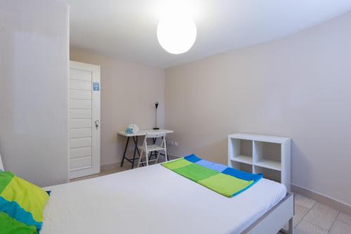 a bedroom with a white bed and a desk at Relógio Guest House in Porto