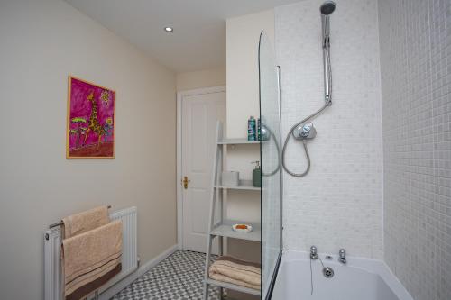 uma casa de banho com um chuveiro e uma banheira em Charming 2-bedroom Apartment Durham em Durham