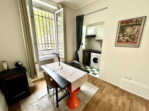 une petite cuisine avec une table et une table ainsi qu'une fenêtre dans l'établissement Central 1BR near Montmartre, à Paris