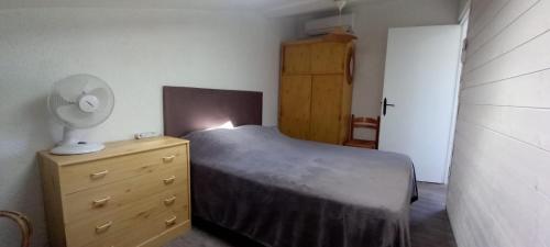 a bedroom with a bed and a dresser with a lamp at La colombe in Argelès-sur-Mer