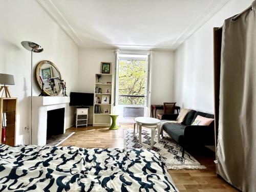 un salon avec un lit et un canapé dans l'établissement Central 1BR near Montmartre, à Paris