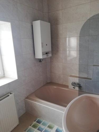een badkamer met een bad, een wastafel en een kast bij Gartenland Gela in Kitzingen