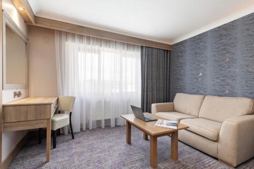 a living room with a couch and a desk at Rochestown Lodge Hotel in Dun Laoghaire
