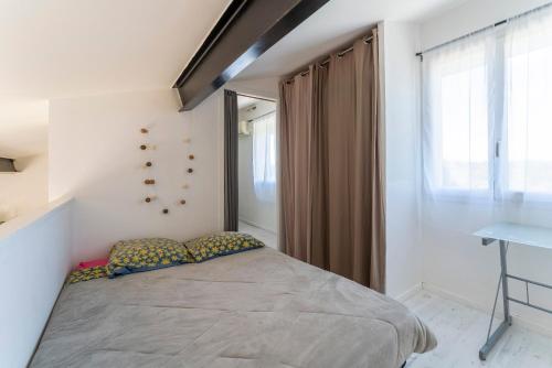 um quarto com uma cama grande e uma janela em loft des cigales em Uchaud