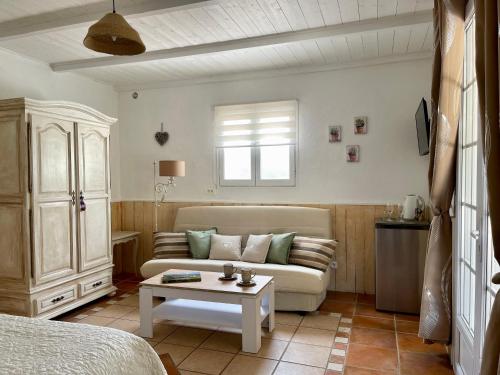 a living room with a couch and a table at Domaine Au Coeur des Alpilles in Maussane-les-Alpilles