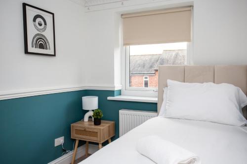 1 dormitorio con cama blanca y ventana en Modern 3-bedroom Retreat, en Swalwell
