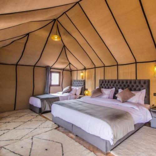 a bedroom with two beds in a tent at marvelous luxury desert stars in Merzouga