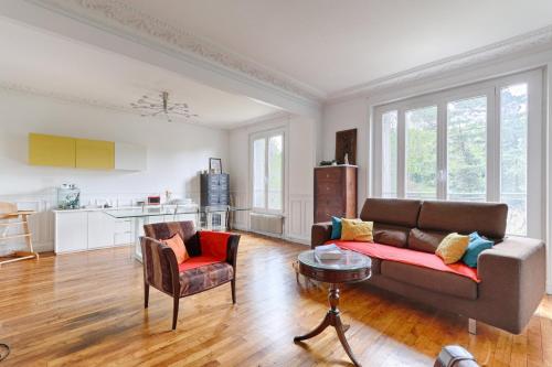 sala de estar con sofá y mesa en Résidor - Appartement 4P chaleureux et lumineux !, en París